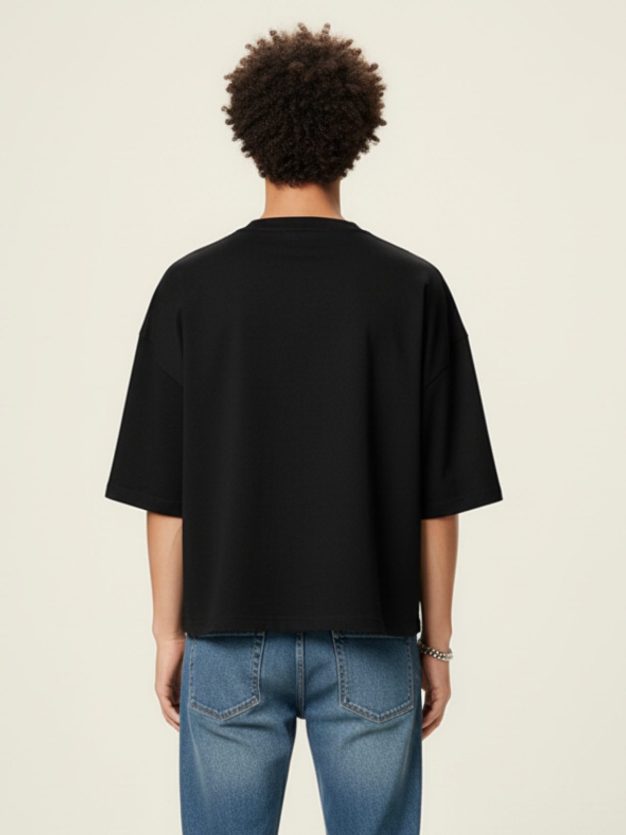 Aero boxy crop tee in black by Apollo Moda, worn with blue jeans, full length view